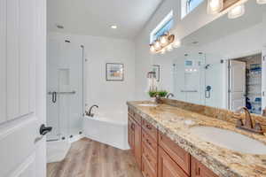 Full bathroom with a sink, a stall shower, and wood finished floors