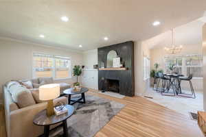 Living area with a notable chandelier, a healthy amount of sunlight, wood finished floors, and recessed lighting
