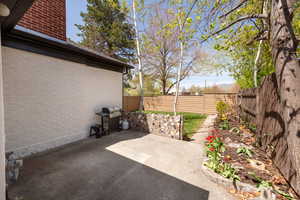 View of patio featuring a fenced backyard and a grill