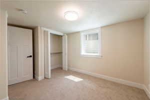 Unfurnished bedroom with baseboards, carpet flooring, and a closet