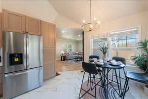 Dining area featuring an inviting chandelier, lofted ceiling, light wood-style floors, and recessed lighting