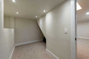 Corridor featuring baseboards, carpet floors, and recessed lighting