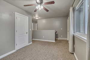 Interior space featuring visible vents, baseboards, ceiling fan, carpet, and a textured ceiling