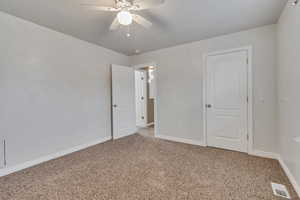 Unfurnished bedroom featuring visible vents, baseboards, a ceiling fan, and light carpet