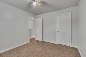 Unfurnished bedroom with carpet flooring, baseboards, and ceiling fan