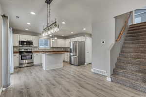 Kitchen featuring light wood finished floors, a sink, visible vents, and stainless steel appliances