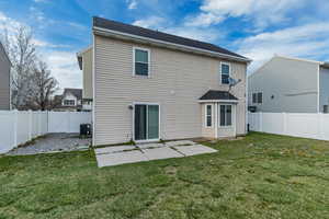 Back of house with a patio, central air condition unit, a fenced backyard, and a lawn
