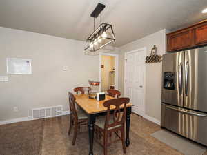 Dining room featuring visible vents, baseboards, and a textured ceiling