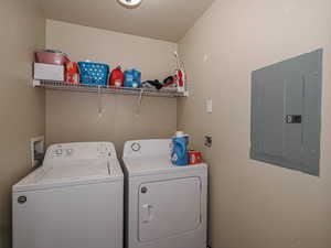 Clothes washing area featuring washer and dryer, laundry area, and electric panel