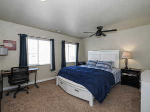 Bedroom featuring ceiling fan, a textured ceiling, visible vents, carpet floors, and baseboards