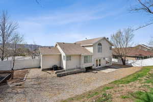 Rear view of property with central AC, a fenced backyard, stucco siding, roof with shingles, and french doors