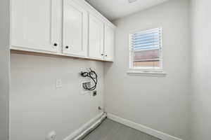 Clothes washing area with baseboards, gas dryer hookup, cabinet space, electric dryer hookup, and hookup for a washing machine