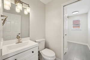 Bathroom featuring toilet, vanity, and baseboards