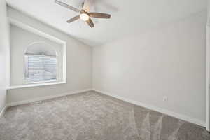 Carpeted empty room with visible vents, ceiling fan, and baseboards