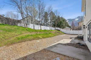 View of yard featuring a mountain view, a fenced backyard, and a patio