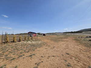 View of yard featuring a rural view, a shed, and an outbuilding