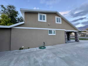 View of property exterior with stucco siding and a patio
