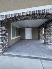 Exterior space with stone siding, an attached carport, and stucco siding