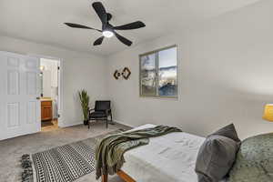 Bedroom with baseboards, a ceiling fan, connected bathroom, and light colored carpet