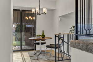 Dining room with a chandelier, baseboards, wood finished floors, and a healthy amount of sunlight