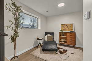 Living area with wood finished floors, baseboards, and visible vents