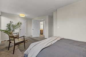 Bedroom with baseboards, attic access, and carpet floors