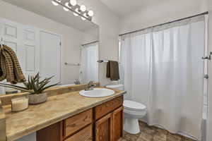 Bathroom with shower / tub combo, vanity, and toilet