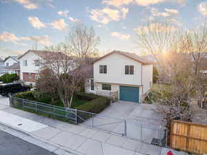 View of front of home with a gate, a garage, driveway, and a fenced front yard