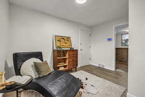 Living area with visible vents, baseboards, and wood finished floors