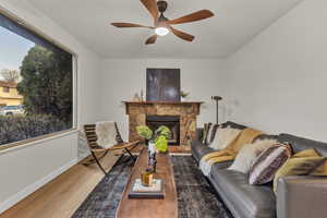 Living room featuring ceiling fan, baseboards, wood finished floors, and a healthy amount of sunlight