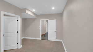 Interior space featuring light carpet, recessed lighting, and baseboards