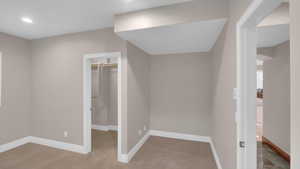 Unfurnished bedroom with baseboards, a closet, a spacious closet, recessed lighting, and carpet floors