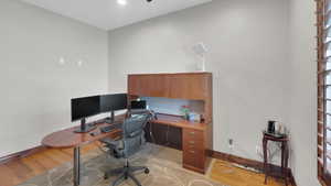 Office space with light wood-type flooring and baseboards