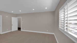 Unfurnished room featuring baseboards, recessed lighting, and light colored carpet