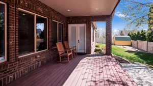 Deck featuring a yard, a fenced backyard, a storage unit, and an outdoor structure