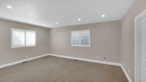 Spare room featuring visible vents, baseboards, and carpet floors