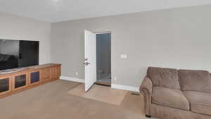 Living room featuring stairway, baseboards, and light colored carpet