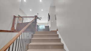 Staircase with baseboards, a ceiling fan, and recessed lighting
