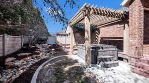 View of yard with a fenced backyard, a pergola, and a hot tub