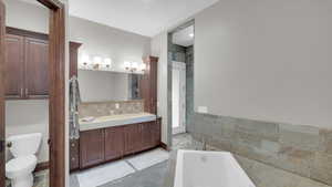 Full bath featuring toilet, vanity, and a garden tub