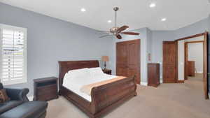 Bedroom featuring baseboards, a closet, recessed lighting, a ceiling fan, and light colored carpet