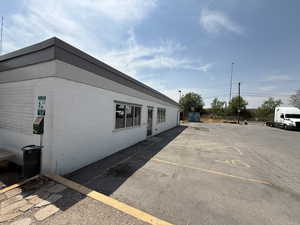 View of property exterior with uncovered parking and concrete block siding