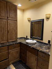 Bathroom featuring vanity, recessed lighting, and dark tile patterned floors