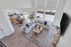 Living area with a towering ceiling, light wood-type flooring, and baseboards