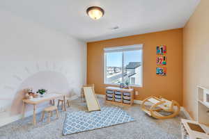 Rec room with carpet flooring, visible vents, and baseboards