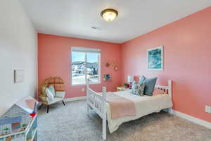 Carpeted bedroom with baseboards and visible vents