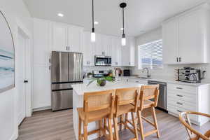 Kitchen featuring a sink, white cabinetry, and stainless steel appliances