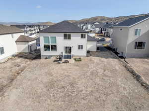 Back of house with entry steps, a mountain view, stucco siding, and a residential view