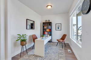 Home office featuring wood finished floors, baseboards, and visible vents