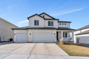 View of front of home featuring concrete driveway, stucco siding, stone siding, central AC unit, and covered porch